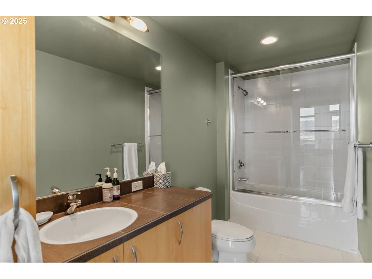 1255 Northwest 9th Avenue, Unit 910 Portland, OR 97209 - Photo 27 of 43 a bathroom with a granite countertop sink mirror vanity and toilet
