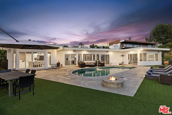 a view of a house with backyard and sitting area
