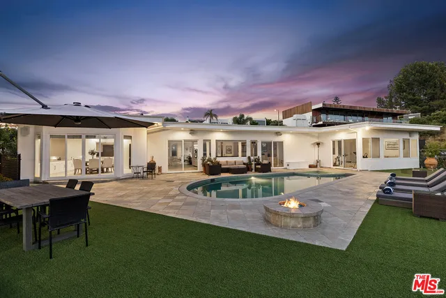a view of a house with backyard and sitting area