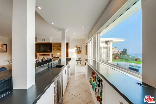 a living room with stainless steel appliances kitchen island granite countertop a table and chairs in it