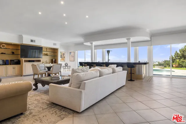 a living room with furniture and a view of kitchen
