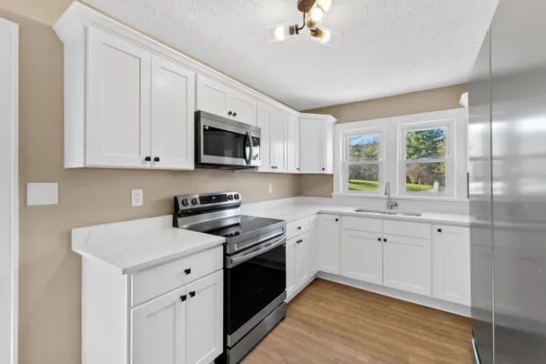a kitchen with white cabinets and stainless steel appliances