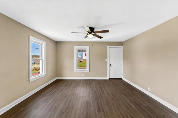 a view of a room with wooden floor and windows