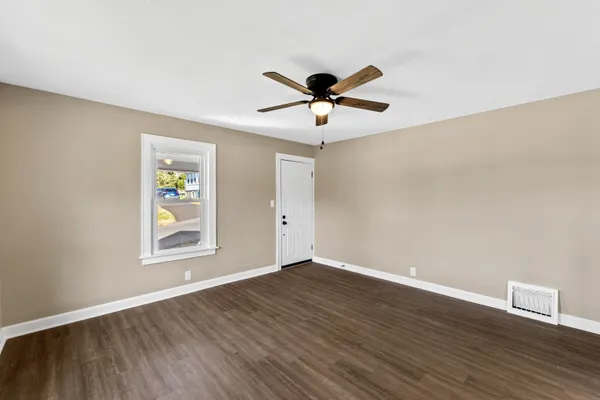 a view of a big room with wooden floor and windows