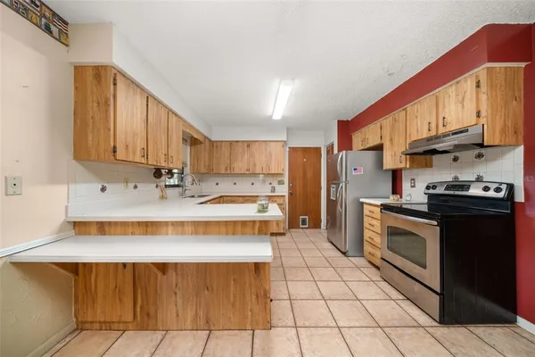 a kitchen with stainless steel appliances a sink stove and cabinets