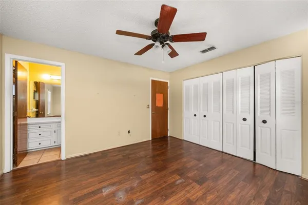 a view of room with wooden floor and ceiling fan