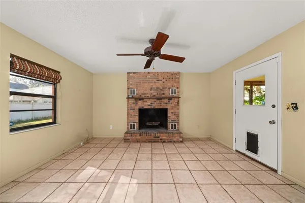 a view of an empty room with a fireplace and a window