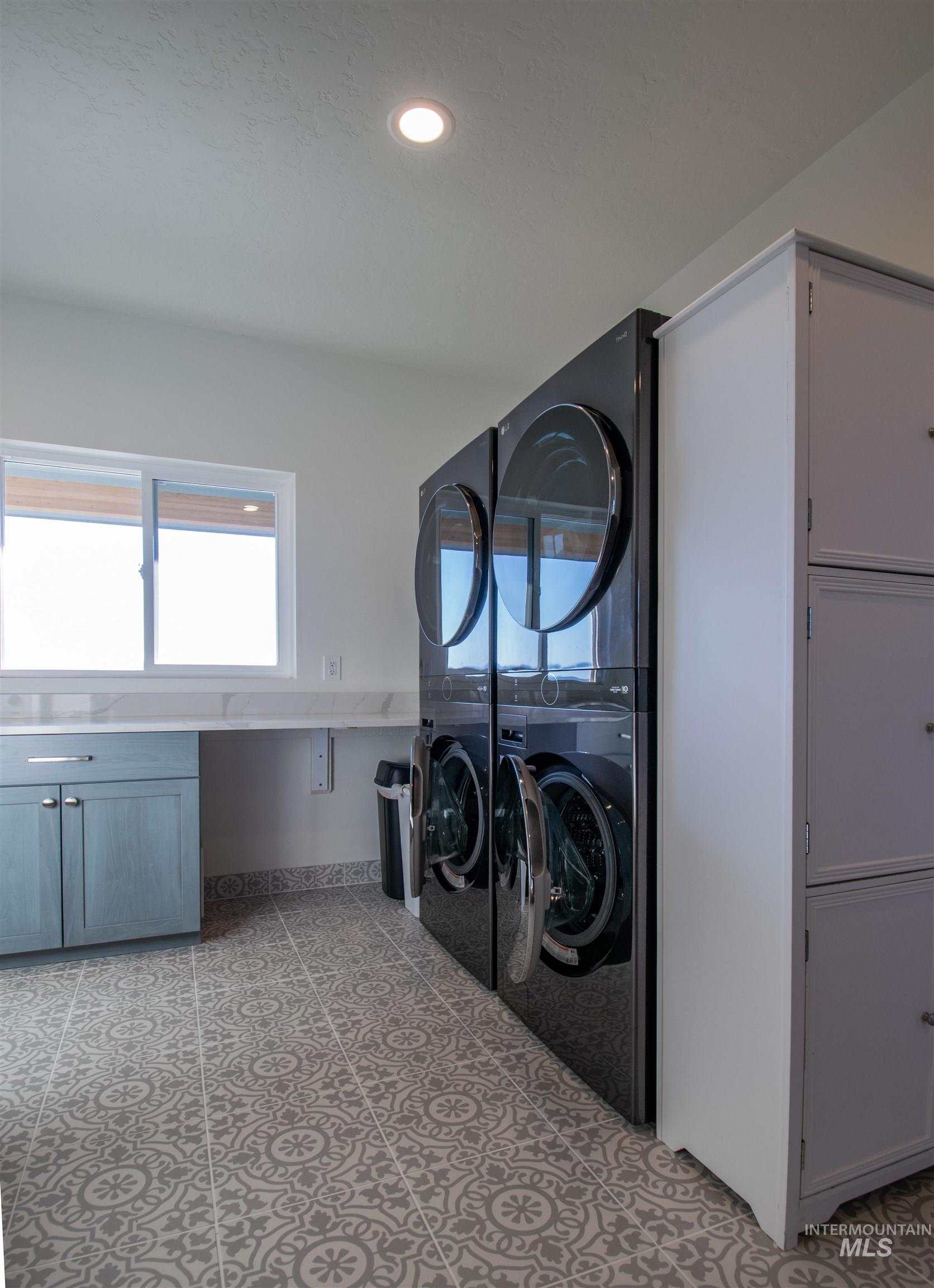 44 Big Moose Road McCall, ID 83638 - Photo 38 of 50 Laundry room featuring patterned floor tiles, recessed lighting, a built-in countertop with an undermount sink, and light blue cabinetry with brushed nickel hardware