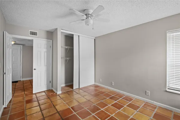 a view of a room with a ceiling fan and window