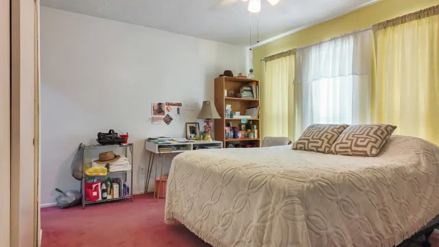 a bedroom with a bed and a large window