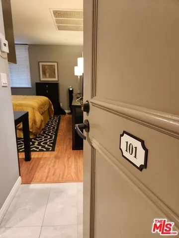 a bedroom with a bed and a view of kitchen