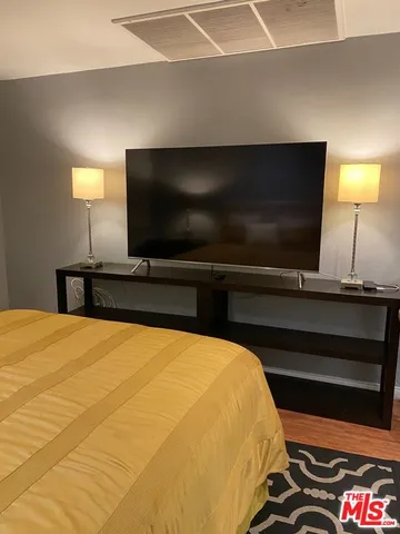 a bedroom with a bed and a television