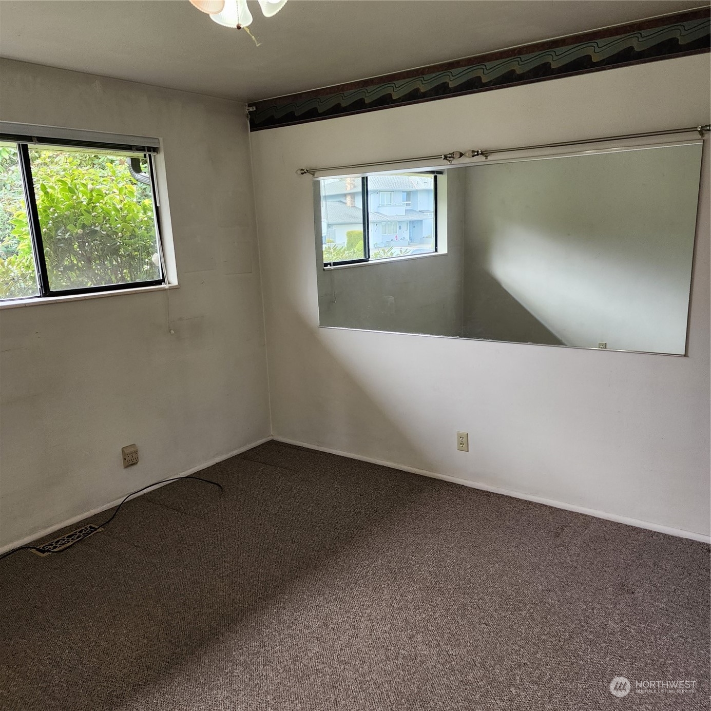 115 Monterey Place Northeast Renton, WA 98056 - Photo 16 of 35 a view of an empty room with wooden floor and a window