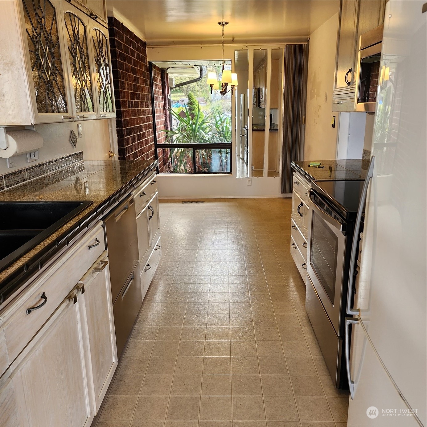115 Monterey Place Northeast Renton, WA 98056 - Photo 9 of 35 a kitchen with granite countertop a stove a sink and a refrigerator