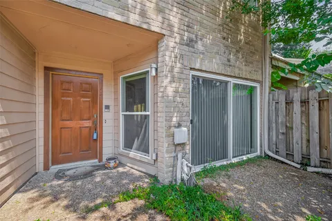a view of yellow house with a yard and large tree
