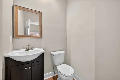 a bathroom with a toilet sink and mirror