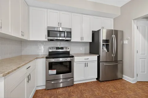a kitchen with stainless steel appliances granite countertop a refrigerator stove and sink