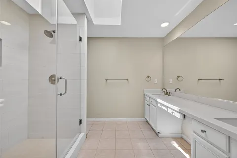 a spacious bathroom with a shower sink and mirror