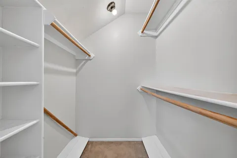 a view of closet with wooden floor