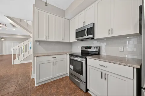 a kitchen with white cabinets stainless steel appliances and sink