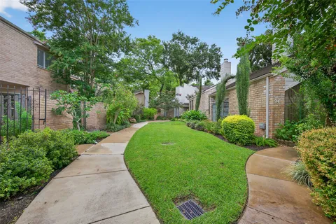 a view of a garden with potted plants and large trees