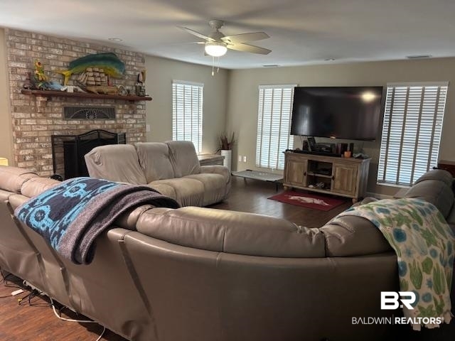 7310 Cook Road Foley, AL 36535 - Photo 9 of 14 Living room featuring a brick fireplace, wood finished floors, and a ceiling fan