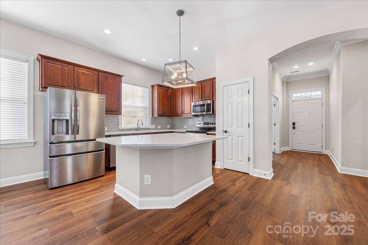 4148 Cedar Point Avenue Matthews, NC 28104 - Photo 17 of 48 a kitchen with stainless steel appliances granite countertop a refrigerator a stove a sink dishwasher and a wooden floor