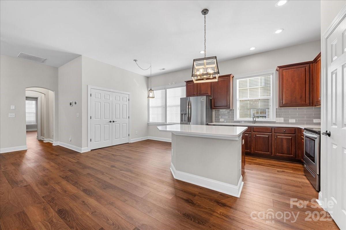 4148 Cedar Point Avenue Matthews, NC 28104 - Photo 23 of 48 a kitchen with stainless steel appliances granite countertop a refrigerator a sink dishwasher a oven and white cabinets with wooden floor
