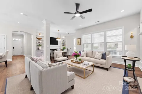 a kitchen with stainless steel appliances granite countertop a refrigerator a sink dishwasher a oven and white cabinets with wooden floor