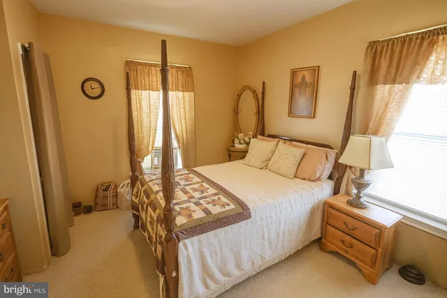 a bedroom with a bed and a dresser next to a window