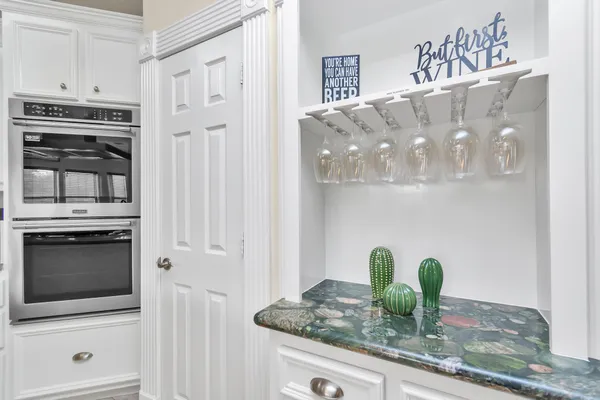 a kitchen with granite countertop white cabinets and stainless steel appliances