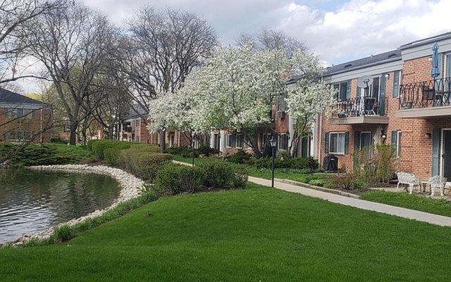 714 East Algonquin Road, Unit J205 Arlington Heights, IL 60005 - Photo 1 of 14 a view of a house with a yard and sitting area