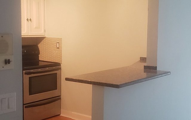 714 East Algonquin Road, Unit J205 Arlington Heights, IL 60005 - Photo 9 of 14 a kitchen with granite countertop white cabinets and white appliances