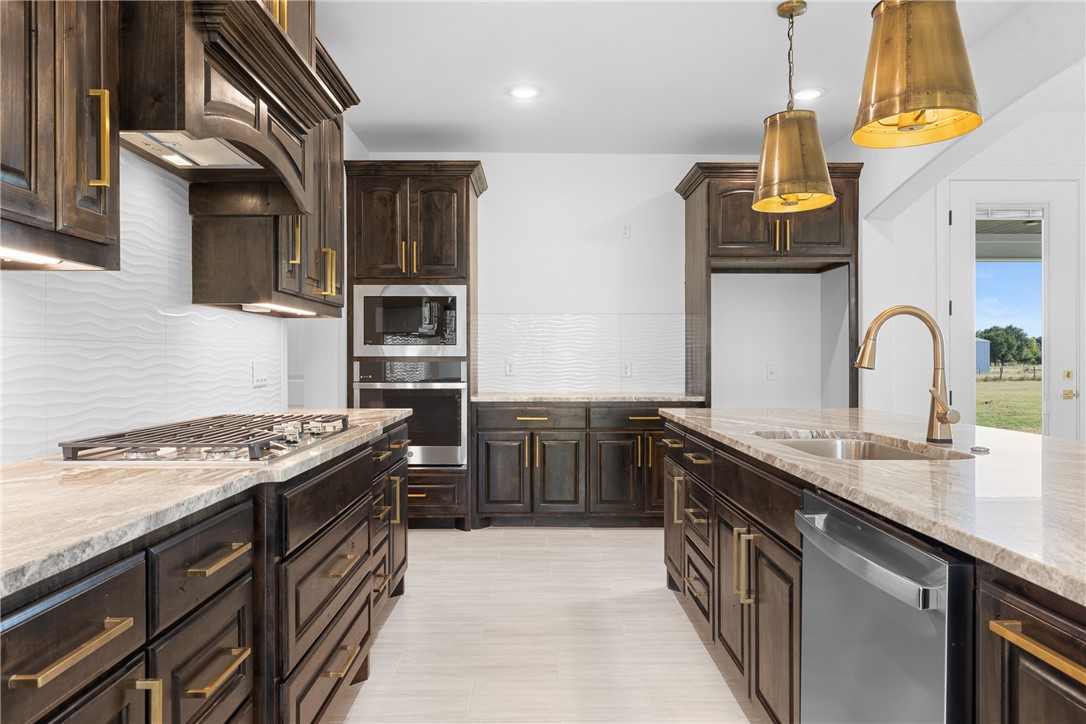 6524 Agave Court Bryan, TX 77808 - Photo 20 of 43 Kitchen with dark brown cabinetry, backsplash, light stone counters, and recessed lighting