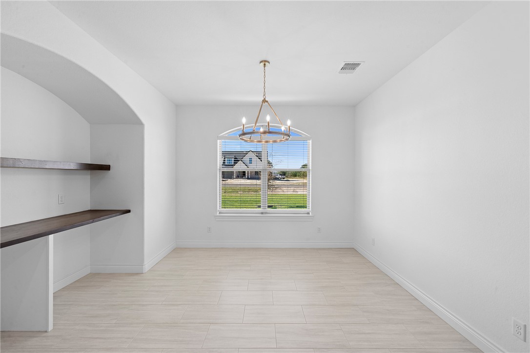 6524 Agave Court Bryan, TX 77808 - Photo 21 of 43 Unfurnished dining area with baseboards and a chandelier