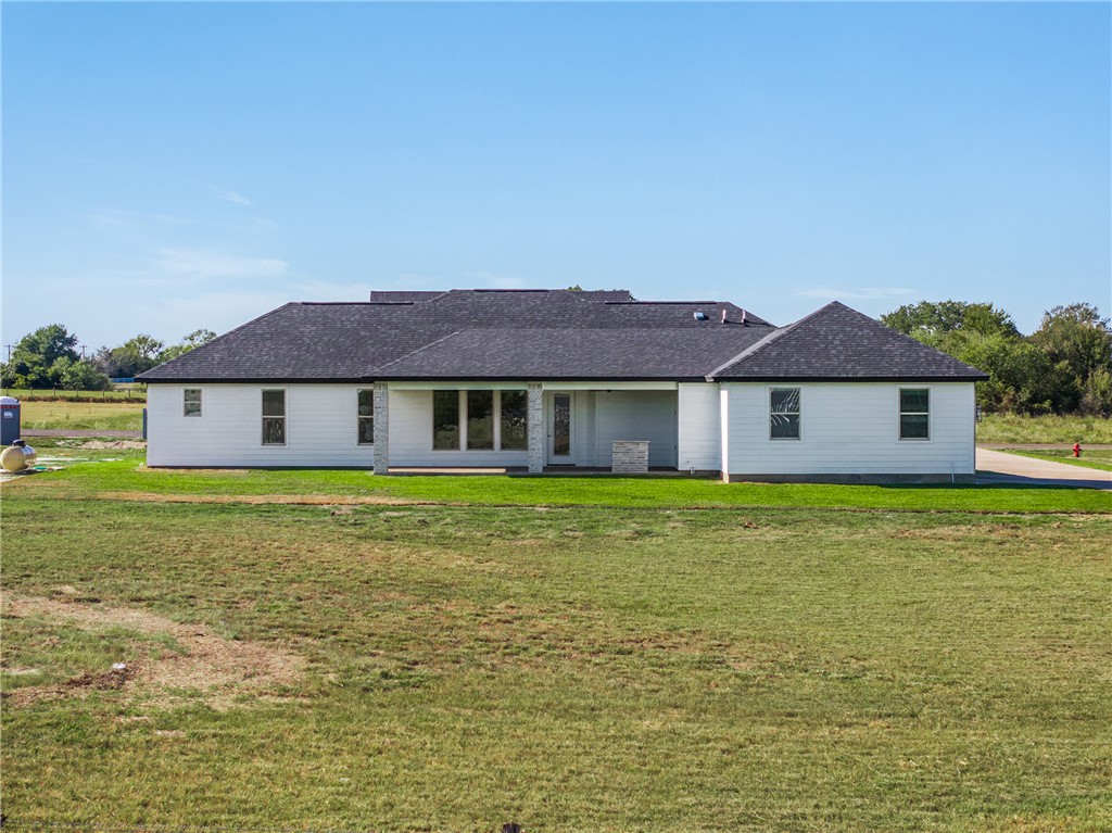 6524 Agave Court Bryan, TX 77808 - Photo 41 of 43 Back of house featuring a lawn, a patio area, and roof with shingles