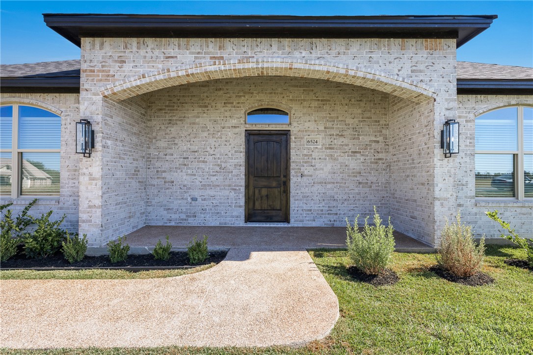 6524 Agave Court Bryan, TX 77808 - Photo 9 of 43 Property entrance with brick siding and a lawn