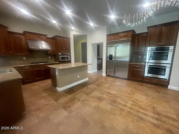 a large kitchen with kitchen island a sink stainless steel appliances and cabinets