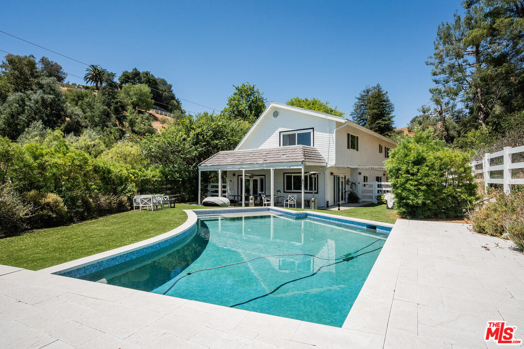 a view of a house with swimming pool and a yard