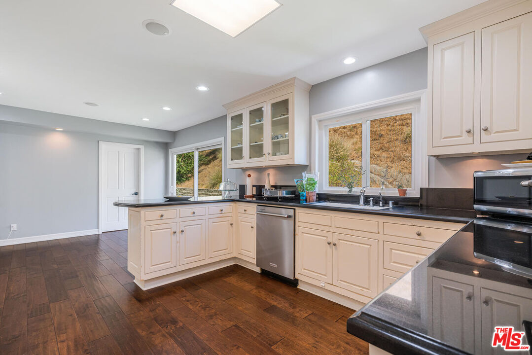 24975 Kit Carson Road Hidden Hills, CA 91302 - Photo 13 of 38 a kitchen with sink cabinets and window