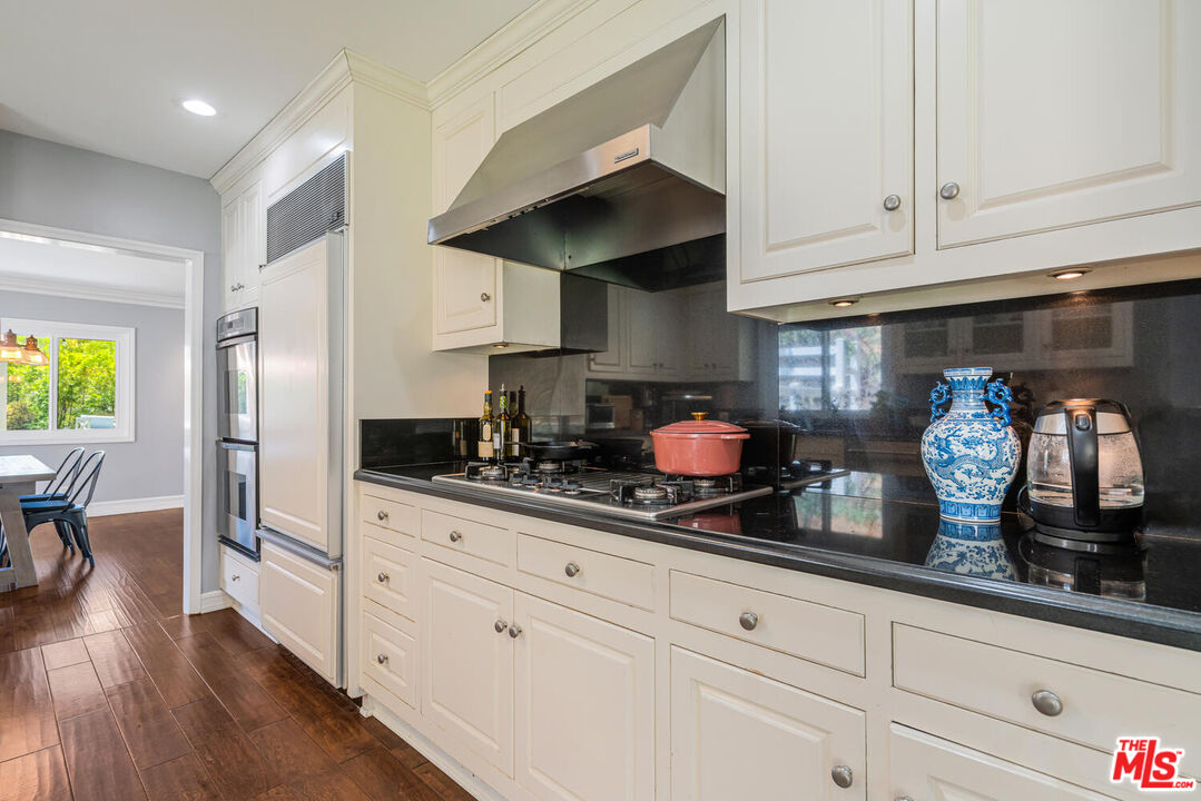 24975 Kit Carson Road Hidden Hills, CA 91302 - Photo 15 of 38 a kitchen with white cabinets and appliances