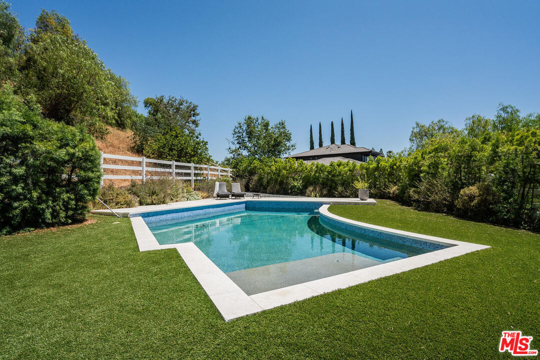 24975 Kit Carson Road Hidden Hills, CA 91302 - Photo 2 of 38 a view of a swimming pool with a yard