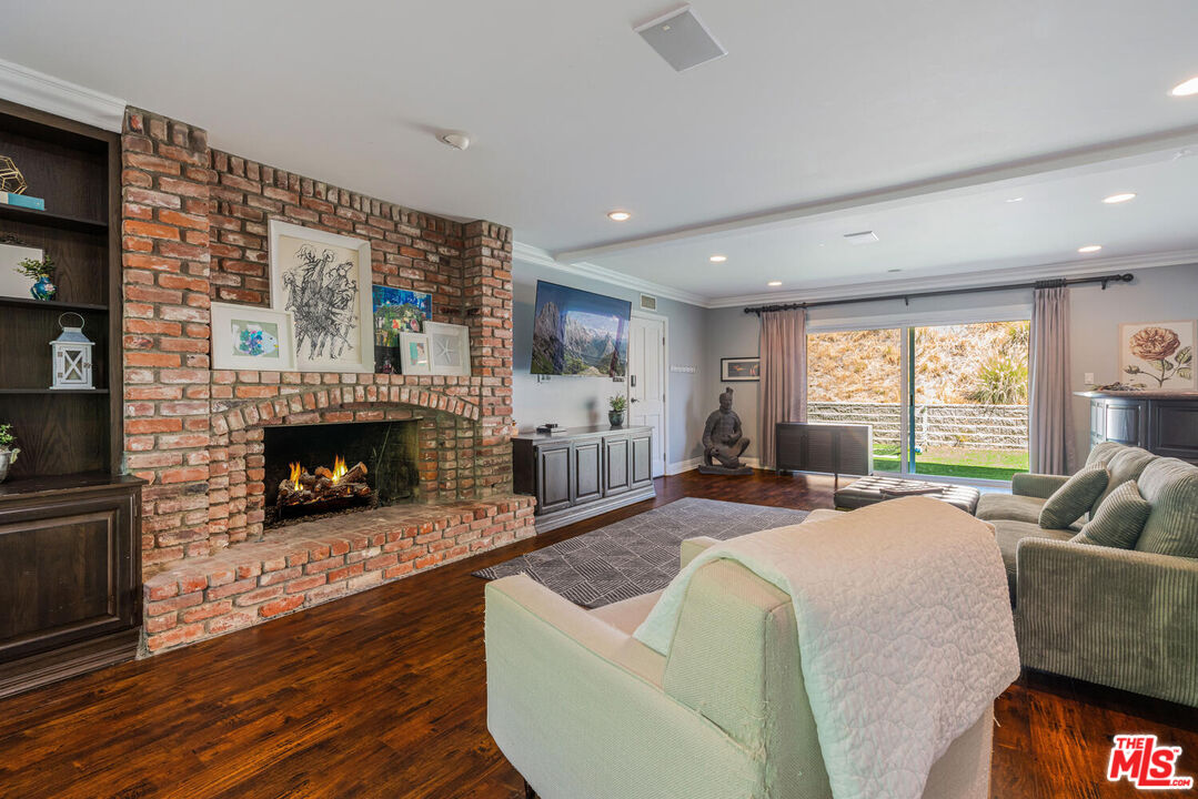 24975 Kit Carson Road Hidden Hills, CA 91302 - Photo 21 of 38 a living room with furniture large window and a fireplace