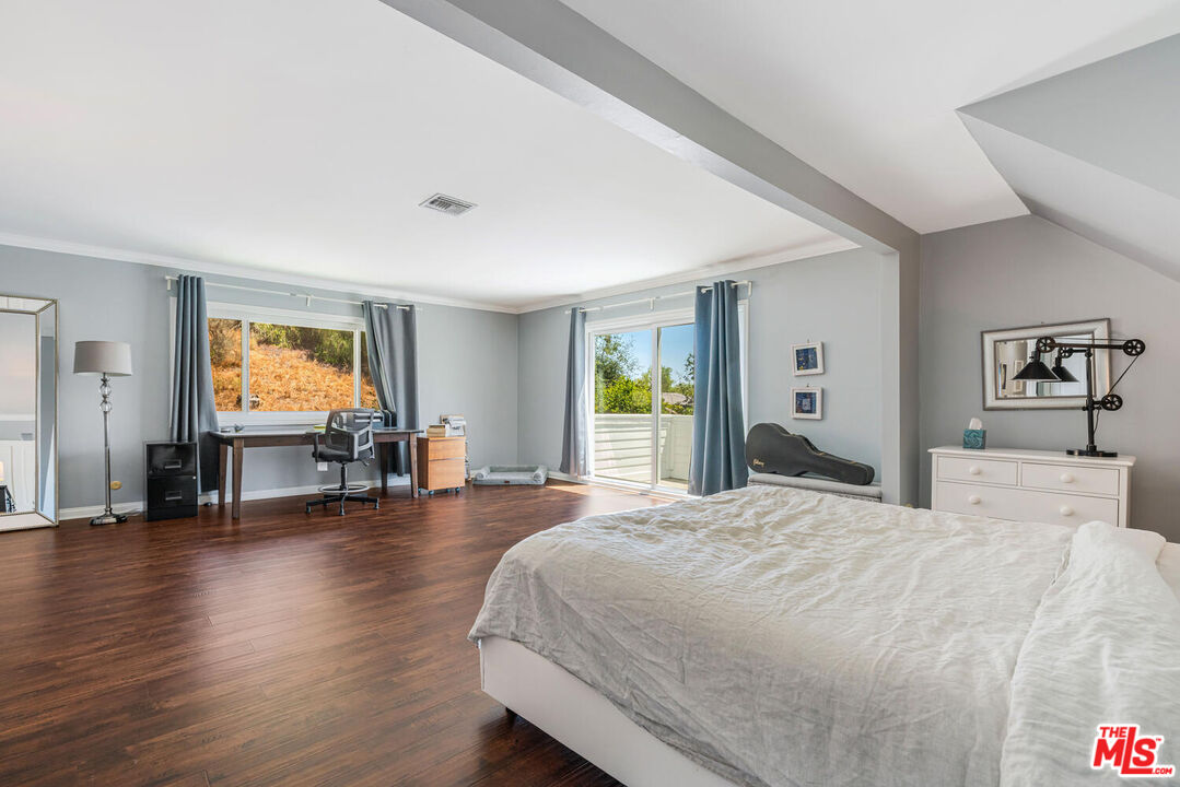 24975 Kit Carson Road Hidden Hills, CA 91302 - Photo 25 of 38 a spacious bedroom with a bed and wooden floor
