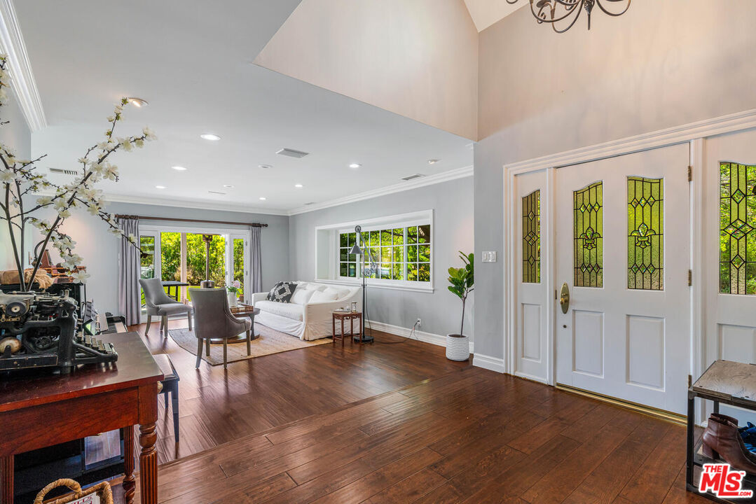 24975 Kit Carson Road Hidden Hills, CA 91302 - Photo 8 of 38 a living room with furniture floor to ceiling window and wooden floor