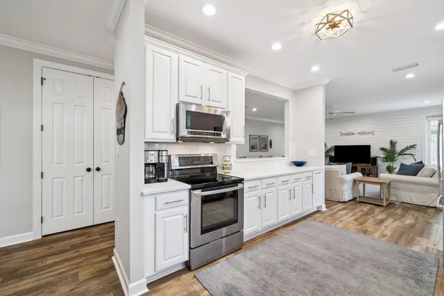 a kitchen with white cabinets and stainless steel appliances
