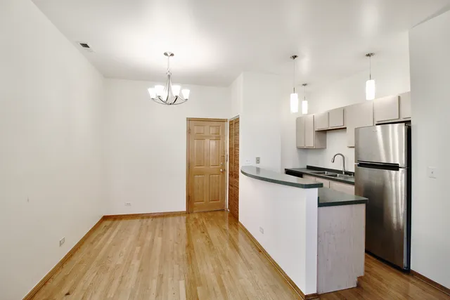 a kitchen with wooden floor and stainless steel appliances