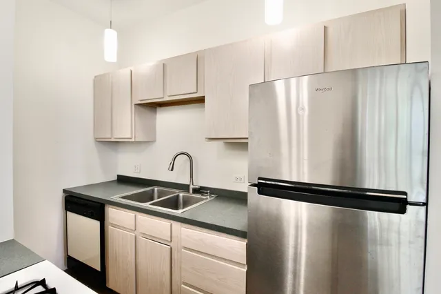a kitchen with stainless steel appliances granite countertop a refrigerator and a sink