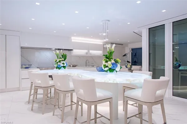 a dining room with kitchen island furniture a chandelier and kitchen view
