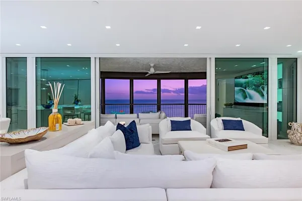 a living room with furniture and large windows